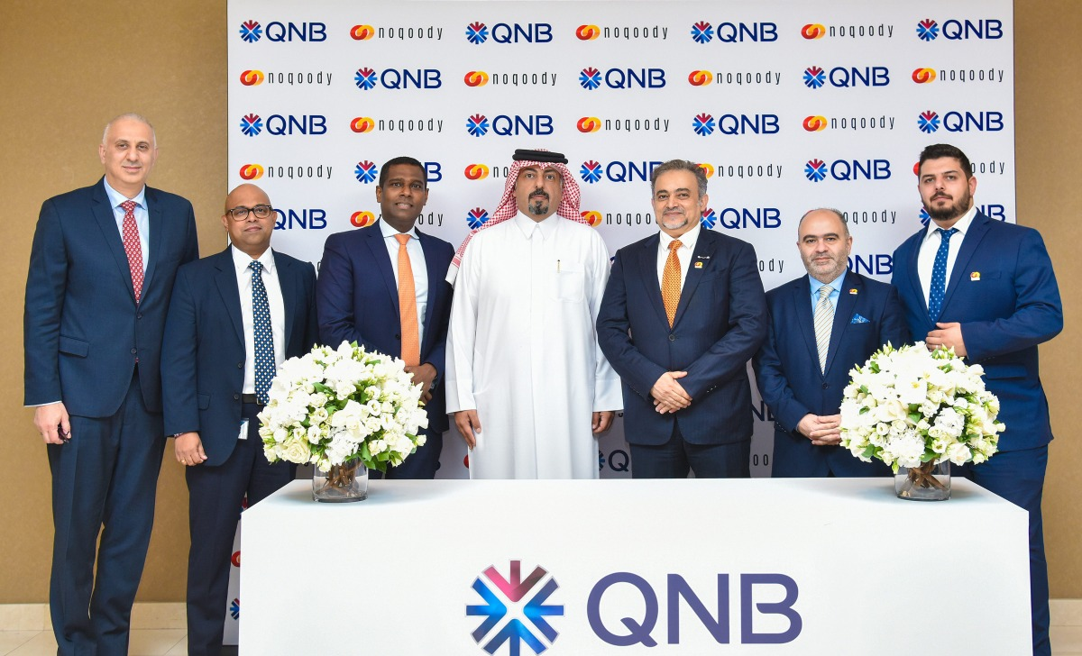 Noqoody and QNB executives at the partnership signing ceremony in Doha, standing before a QNB and Noqoody branded backdrop
